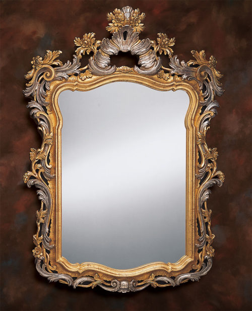 17th century Venetian style mirror in carved wood frame. Frame of this wall mirror is carved in deep relief with leaf and floral design and finished and hand applied antiqued gold and silver metal leaf