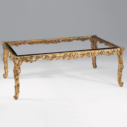 Rectangular carved wood coffee table with leaf motif. Carved coffee table has antiqued gold-leaf finish and thick beveled glass top. This carved wood table is hand-made in Italy