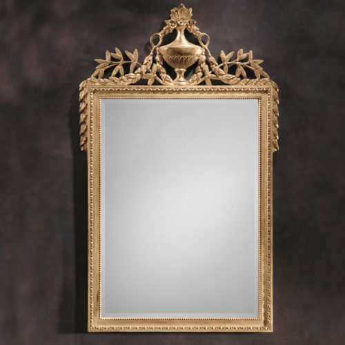 Empire style carved wood decorative mirror with urn and leaf motif. Mirror has a beveled glass and antiqued gold leaf finish. This mirror is hand-crafted in Italy
