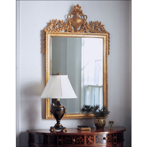 Empire style carved wood decorative mirror with urn and leaf motif. Mirror has a beveled glass and antiqued gold leaf finish. This mirror is hand-crafted in Italy