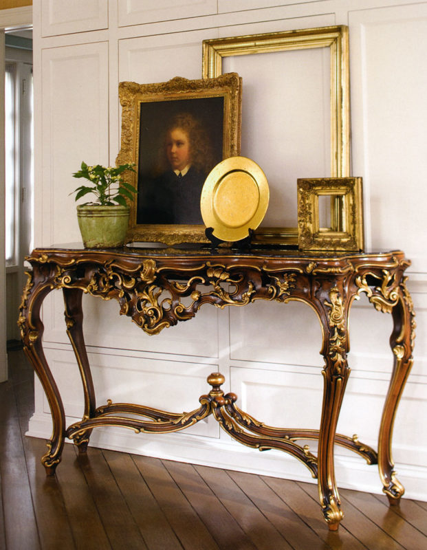 Beautiful interior with hand-crafted in Italy 18th-century French style carved wood console table. French console table has hand-painted medium brown finish, antiqued gold-leaf trim and black Marquina marble top