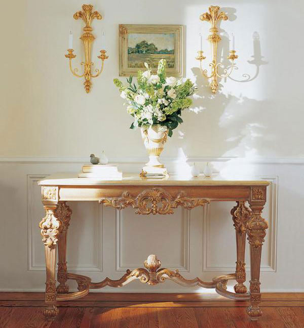 Home entrance decor featuring Louis XIV style carved wood console table with Valencia marble top and carved wood sconce with palm leaf motif in gold leaf finish; console table is available at InvitingHome.com