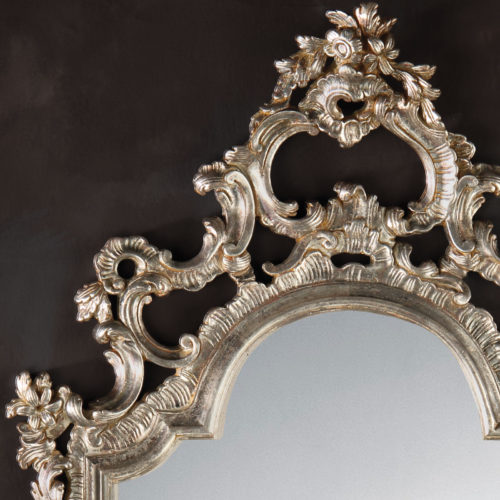 This elegant carved wood mirror is hand crafted in 18th century Italian style. Decorative wall mirror has floral design with graceful leaf scrolls and finished in antique silver leaf. This mirror is hand-crafted in Italy