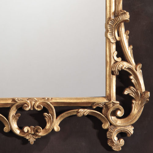 Chippendale style carved wood mirror with leaf and scroll design. This carved mirror finished in antiqued gold-leaf; hand-crafted in Italy