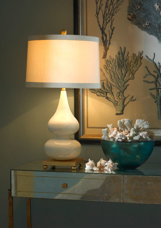 Costal interiors and nautical decor inspiration. This elegant lamp is crafted from double gourd ceramic and mounted on a gold leaf base. It’s curvy silhouette is finished with a milky white glaze
