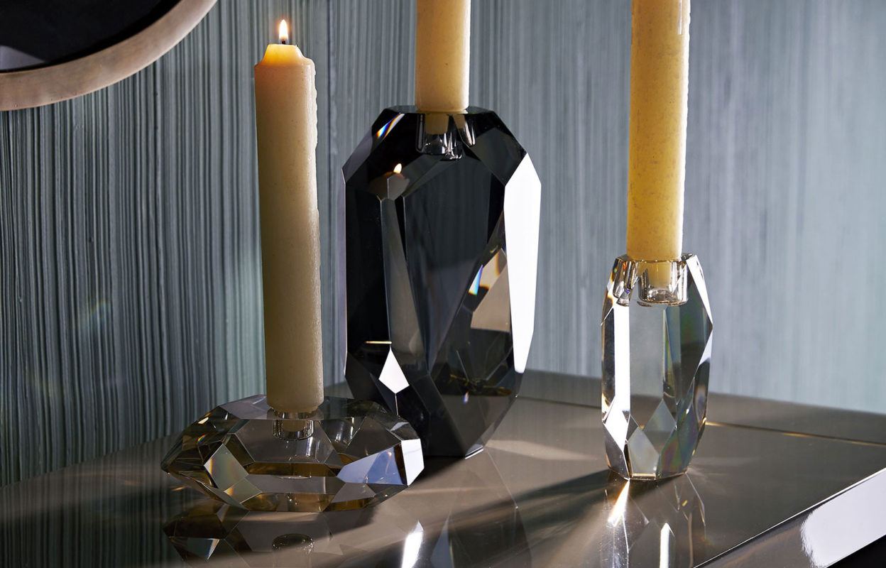 crystal accessories; ri-set of crystal candleholders. The champagne and smoke finishes on the diamond-like facets creates an arresting blend of elements and colors. The defined edges are highlighted by the contents of a taper candle. When grouped together, this set creates quite the lustrous trifecta.