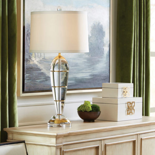 Elegant interior setting with crystal table lamp, oil painting, decorative boxes on the top of an antiqued cabinet; interior design ideas; decorating inspiration
