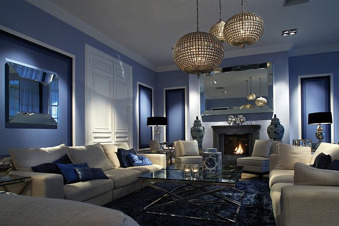 Contemporary living room decor with paneled walls, fireplace mantel mirror and elegant lighting; living room design ideas; blue living room inspiration