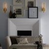 Super modern and luxurious living room and modern fireplace featuring luxe antique brass sconce. Scones create an indirect light that adds depth with modern luxury.