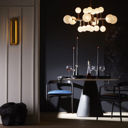 gorgeous dining room with sleek brass sconce and round dining table. Modern lines with soft brass hues make for a luxurious interior