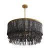 The layered concentric construction is crafted from wood and coconut beads that are strung along an antique brass frame, showcasing a melange of smoky hues. Coconut shell talons hang from the wood bead strands. Though light and airy, this 3-light chandelier establishes a strong natural presence in any setting.