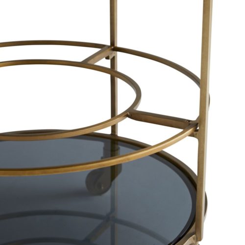 bar cart details. A minimalistic, antique brass-finished iron frame features three-tiered, black glass shelves to stylishly stow mixers and hors d'oeuvres.The top tray is removable and the circular bottom rack is designed to hold bottles