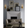 Interior setting features wall decor, modern sconces and decorative vases over the white fireplace mantel; interior design ideas