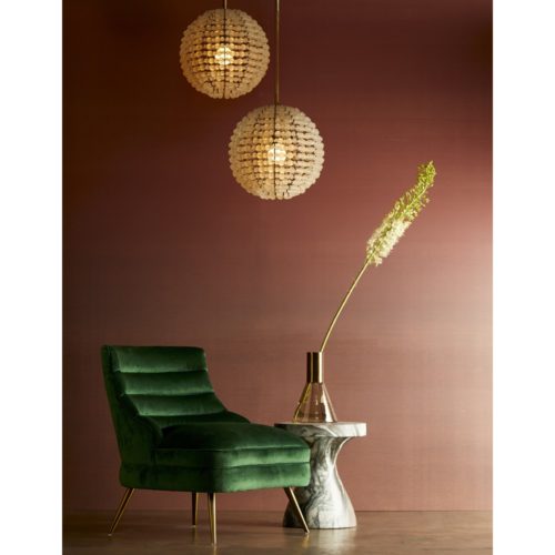 Elegant contemporary seating. Emerald green velvet chair with curves. Chair is accented perfectly with the frosted glass globe pendant light.