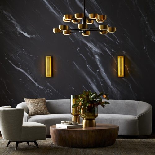 super chic modern living room. Featuring dark gray walls with antique brass accents and drum style coffee table.