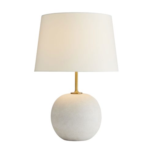 An exaggerated antique brass stem reveals an oversized white orb foundation composed of rice stone.A functional art piece in its simplest form for traditional and modern settings. Topped with an ivory microfiber drum shade with ivory cotton lining and a 1" brass sphere finial.