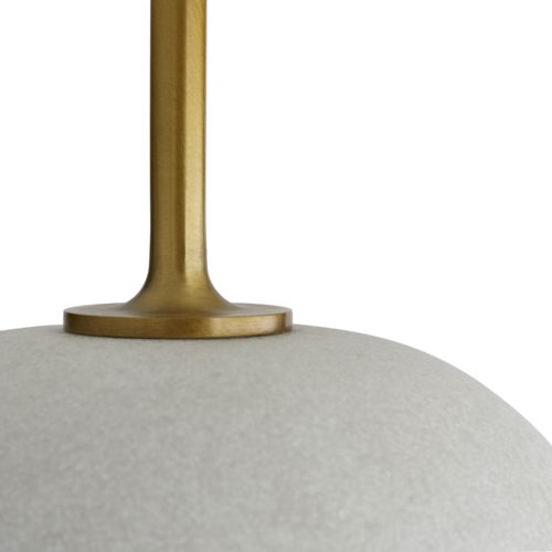 An exaggerated antique brass stem reveals an oversized white orb foundation composed of rice stone.A functional art piece in its simplest form for traditional and modern settings. Topped with an ivory microfiber drum shade with ivory cotton lining and a 1" brass sphere finial.