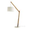 The industrial inspired, fixed-angle natural teak arm is mounted into a cream concrete base. Running along itslength is a gray cloth cord that suspends the lamp at different heights—the extra length can be wrapped around the mounted anchor on the side. The lamp is fitted with an ivory linen drum shade with ivory cotton lining and a dimmer switch.