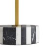 A sleek iron top finished in antique brass juxtaposes with a solid, black-and-white-striped marble base, defining the simple symmetry of this functional showpiece