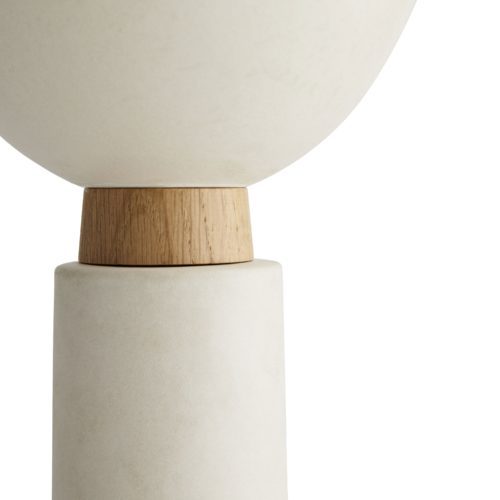 The three ceramic forms play with mixed materials, juxtaposing matte ceramic against oak plinths.