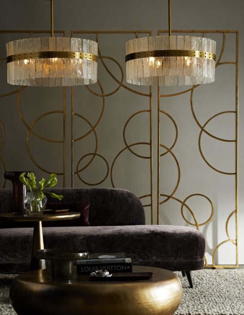 Elegant chandelier with gold leaf room screens. Accented beautifully with a purple velvet chaise.