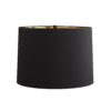 The streamlined steel form features glossy back enamel paired with a heritage brass overlay, cage-like in form. Topped with a black microfiber shade with a gold foil interior.
