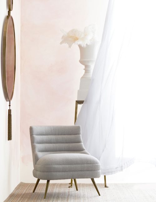 Soft palettes create this elegant sitting area. Plush gray linen accent chair with white curtains and Rose gold mirror.