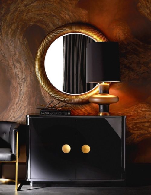 Sophisticated modern interior with modern oak chest and gold accented round mirror.