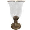 This elegant hurricane lamp is handcrafted from solid brass and has a hand-blown glass chimney. Hurricane lamp has a solid brass base and rim in an antiqued finish. The round footed base of the hurricane lamp is richly embellished with wreath and ribbon trim.