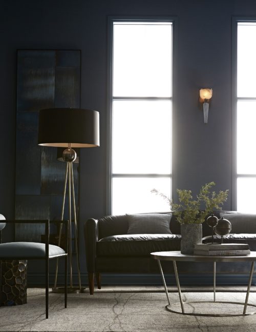 Elegant living room with blue and black hues. A warm and cozy space, inviting you to snuggle on the deep dark leather sofa.