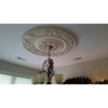 Installation of ceiling medallion with chandelier, flower and scroll design